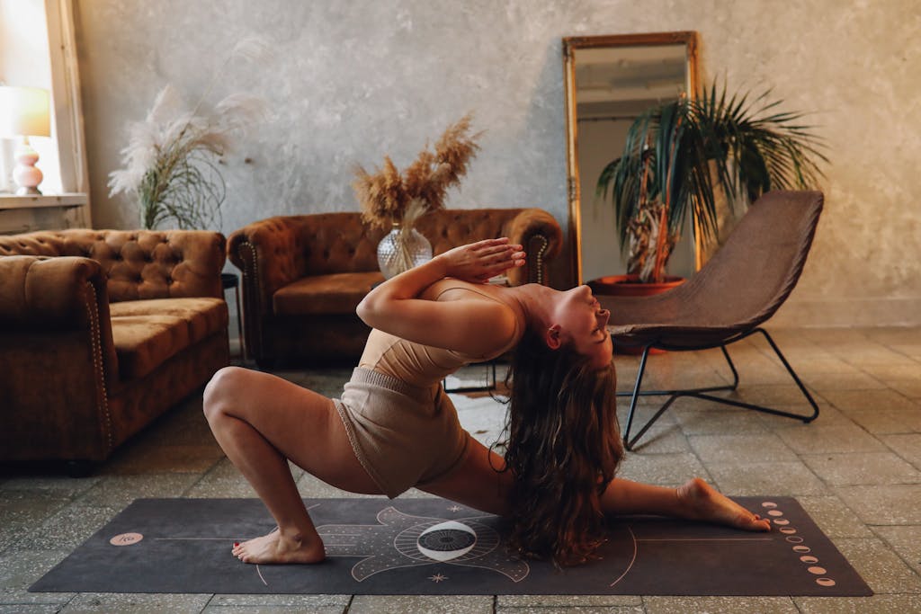 A woman practicing yoga indoors, capturing a moment of calm and flexibility on a yoga mat.