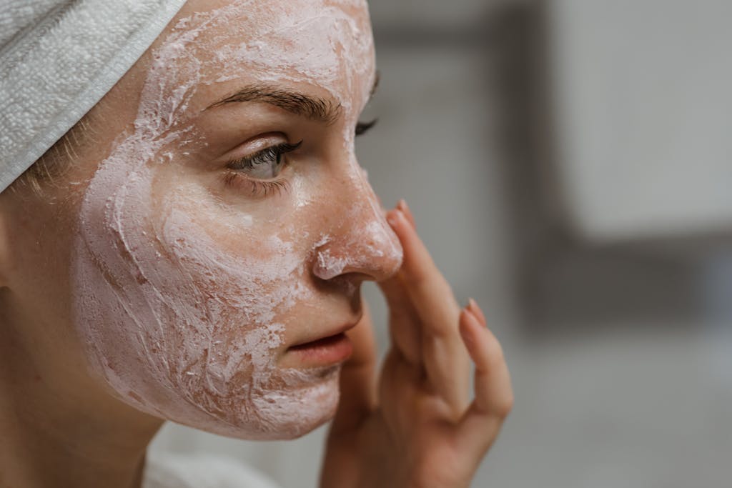 Close-up of a woman applying facial cream as part of her skincare routine, enhancing skin health.