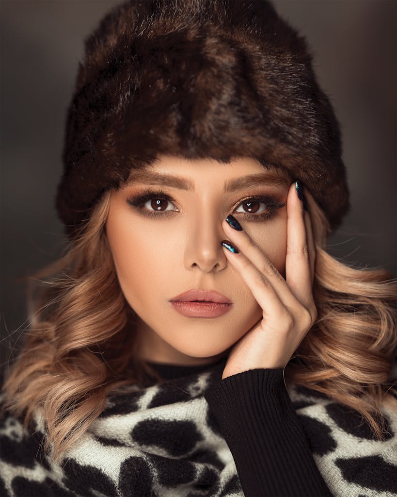 Close-up portrait of a woman in winter fashion with elegant makeup and fur hat.