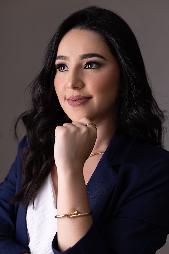 Elegant portrait of a woman with long black hair in a studio setting.