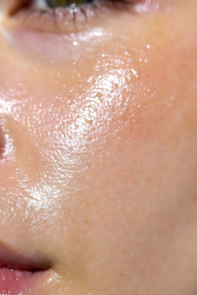 radiant facial skin showing natural glow and healthy texture. The skin has visible dewiness with tiny light reflections suggesting hydration.